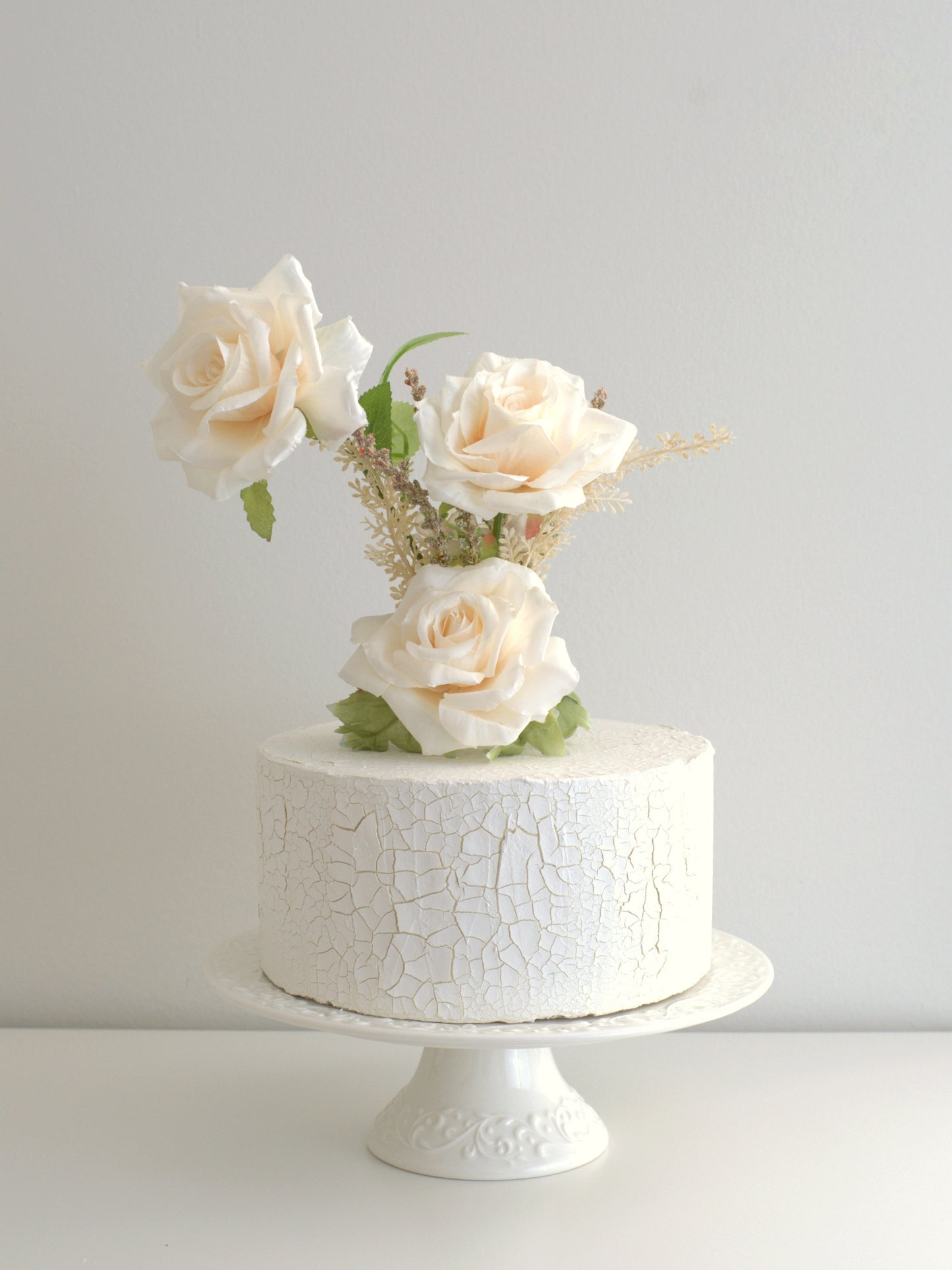  Rose Cake Topper elegantly placed on a cake, featuring high-quality artificial flowers for weddings and special occasions.