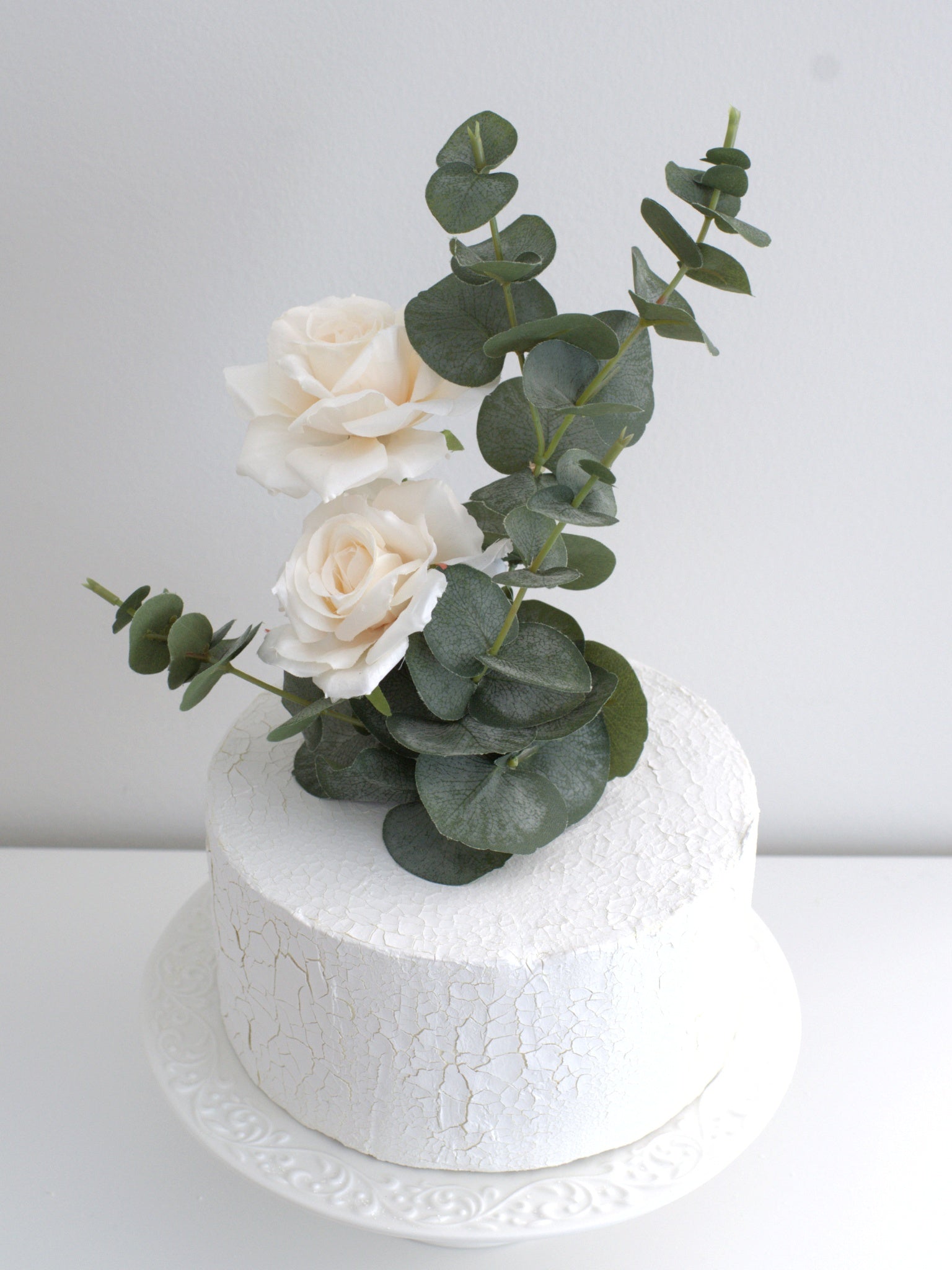 Effortless to apply Rose & Eucalyptus Cake Topper, easily placed on a cake to create a stunning, professional look with high-quality artificial flowers.