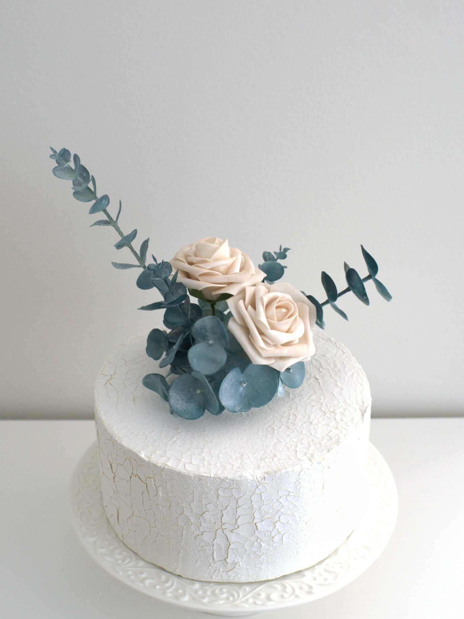 Simple to apply Rose and Eucalyptus Floral Cake Topper, effortlessly adding elegance to cakes with high-quality artificial flowers.