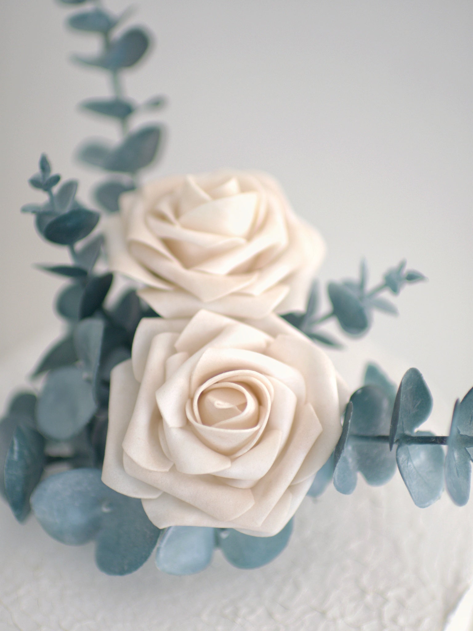 Close-up of Rose and Eucalyptus Floral Cake Topper, showcasing intricate details of high-quality artificial roses and eucalyptus leaves for a lifelike, elegant look.